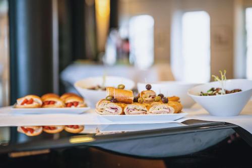 a table with plates of pastries and bowls of food at Radisson BLU Balmoral in Spa