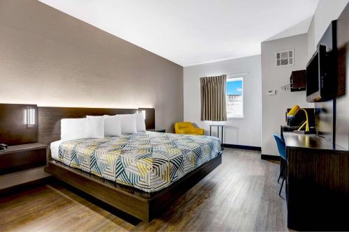 ein Hotelzimmer mit einem Bett und einem gelben Stuhl in der Unterkunft Motel 6-Weatherford, TX in Weatherford