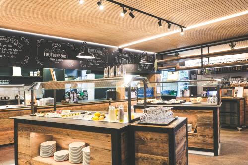 a restaurant kitchen with a counter with food on it at Frutigresort in Frutigen