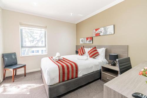 una camera con letto, scrivania e finestra di Best Western Plus Camperdown Suites a Sydney