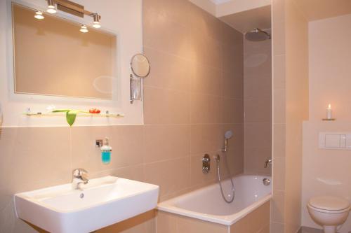 a bathroom with a sink and a toilet and a mirror at Hotel Kiez Pension Berlin in Berlin