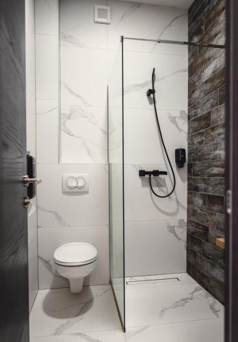 a bathroom with a glass shower stall with a toilet at Hotel Brčko gas Bijeljina in Bijeljina