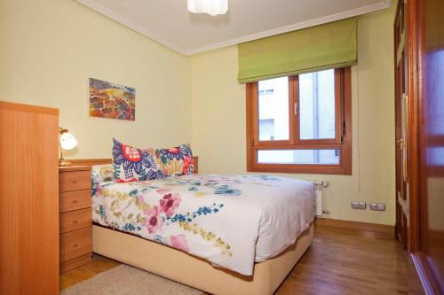 a bedroom with a bed and a dresser and a window at Apartamento de La Casona de Riomera in Oviedo