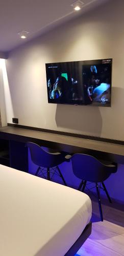 a room with two chairs and a flat screen tv at Leoni Hotel & Private Spa in Citta' Sant'Angelo