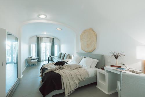 a white bedroom with a bed and a desk at Mykonos Blanc - Preferred Hotels & Resorts in Ornos