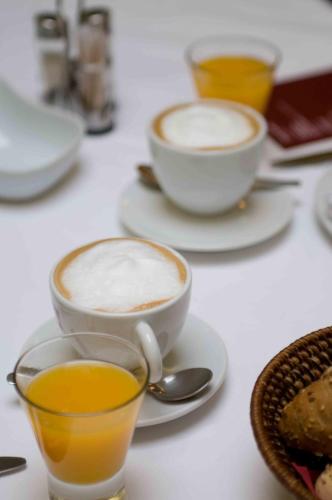 three cups of coffee on a table with spoons at Hotel Merlot in Louny