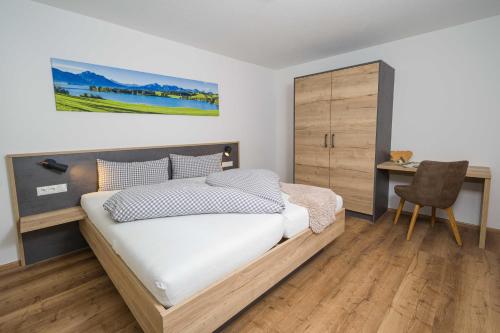 una camera da letto con un letto, una scrivania e una sedia di Ferienwohnung Martin a Seeg