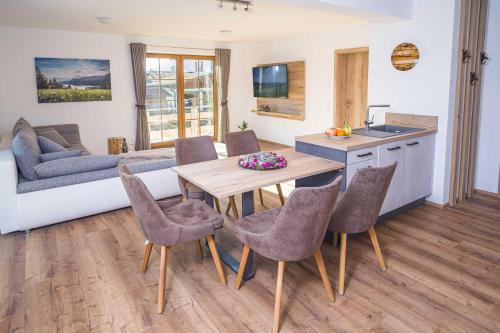 una cucina e un soggiorno con tavolo e sedie in legno di Ferienwohnung Martin a Seeg