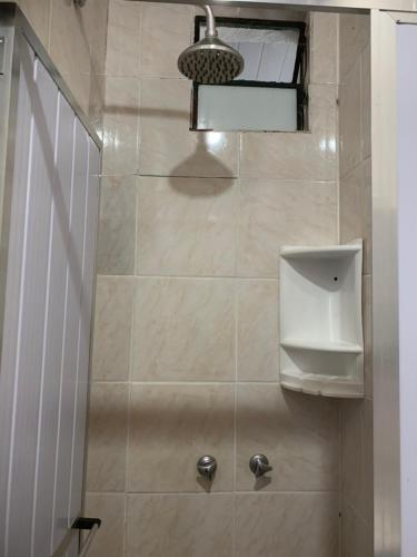 a bathroom with a shower with a toilet and a light at Pousada e Restaurante Tio Paulo in Teresópolis