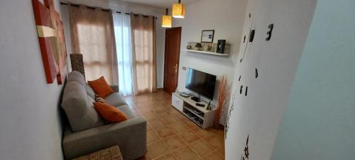 a living room with a couch and a television at Vivienda vacacional in Puerto del Rosario