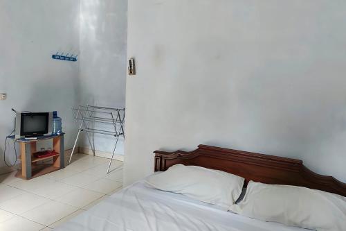 a bedroom with a bed and a tv on a table at Pondok Herrlanda in Pangandaran