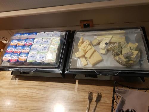 two trays of cheese and other foods on a table at KYRIAD ORANGE Centre Ville - HOTEL & RESTAURANT & BAR - La Galerie d'Art des Princes - Provence Alpes Côte d'Azur - France - Proche A7-A9 - exit21- Châteauneuf-du-Pape Avignon Bollene Nimes - 24h-24h in Orange