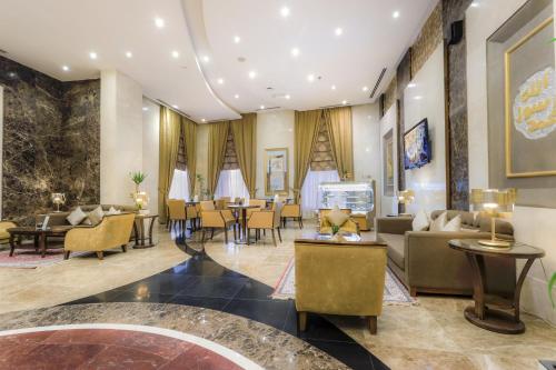 a lobby with couches and tables and chairs at Elaf Kinda Hotel in Makkah