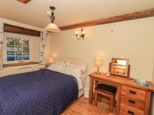 a bedroom with a bed and a desk and a mirror at The Cobbles in Penrith