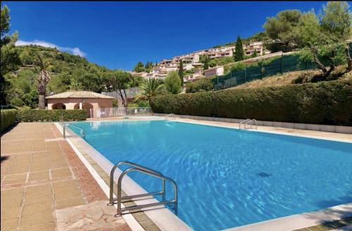 une grande piscine bleue avec une colline en arrière-plan dans l'établissement 10 à 12 pers FAMILLE Amateurs randonnée Boulouris Panorama Saint Raphael Tennis Piscine partagé, à Saint-Raphaël