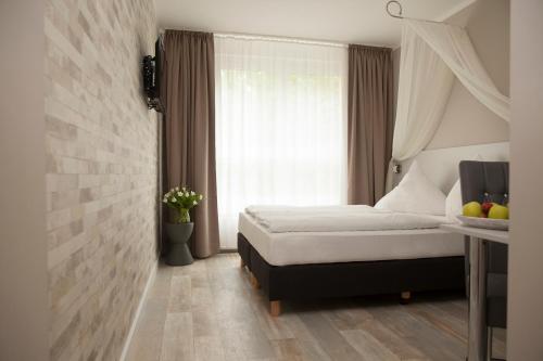 a bedroom with a bed in front of a window at Hotel Kiez Pension Berlin in Berlin