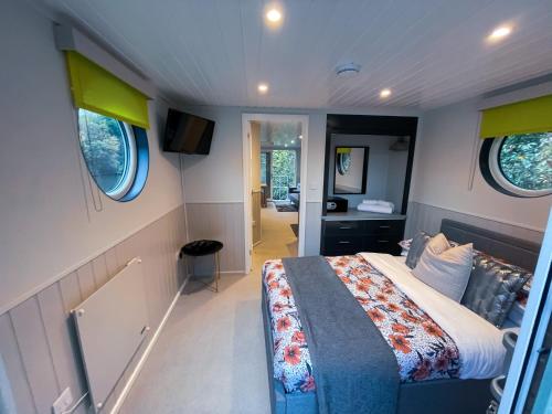 um quarto com uma cama e uma televisão em Lady Florence, Maidstone a Unique River Boat with Castle Views em Kent