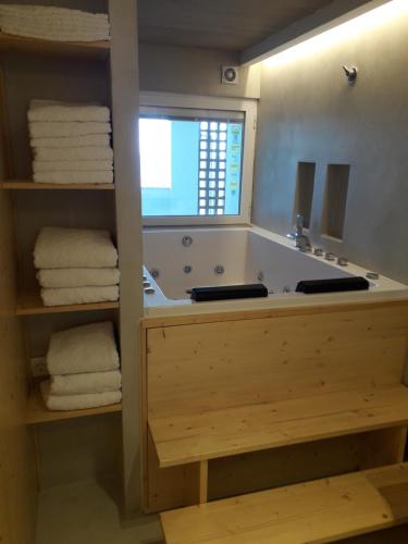 a bathroom with a tub with a mirror and towels at jacuzzi & sauna apartment ! in Salou