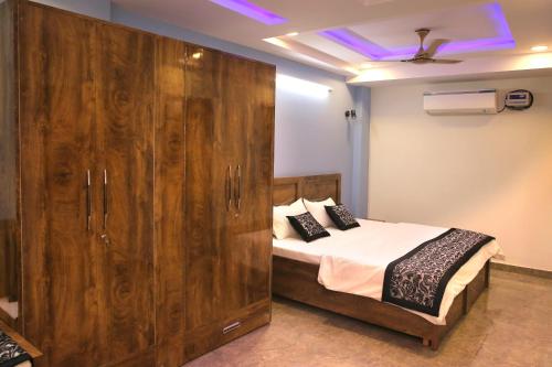 1 dormitorio con 1 cama y un gran armario de madera en CASA CENTRAL en Nueva Delhi