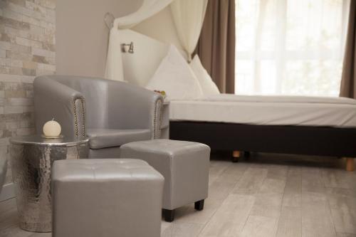 una camera con letto, sedia e sgabello di Hotel Kiez Pension Berlin a Berlino