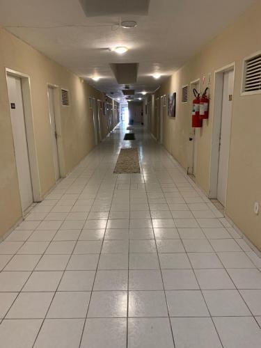 an empty hallway in a building with a tile floor at CP Hotel Economic in Natal