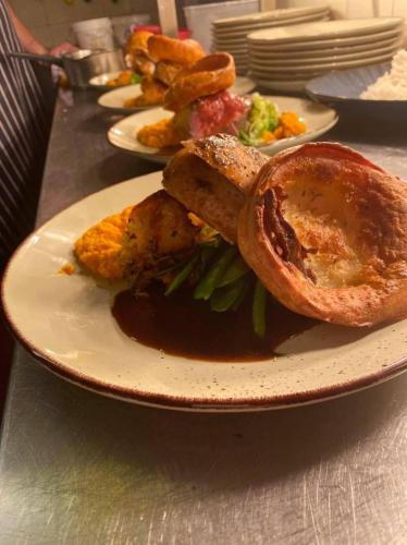 a plate of food with meat and vegetables on a table at Crosskeys Inn Guest Rooms in Wye Valley in Hereford