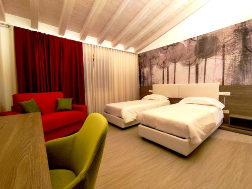 a hotel room with two beds and a red couch at Hotel Luna in Vigonovo