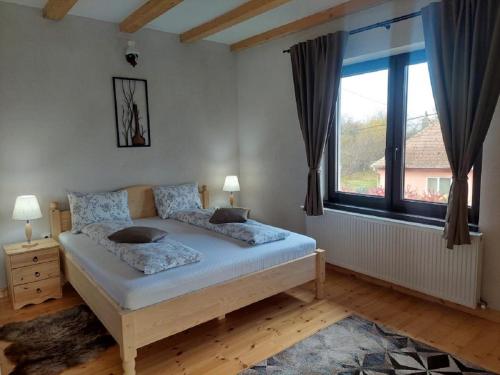 a bedroom with a bed and a large window at Casa Oaspeti Transfagarasan in Cîrţişoara