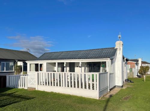 a house with a white fence and a yard at Seabirds - 3 bed chalet, dog friendly, Bridlington in Bridlington
