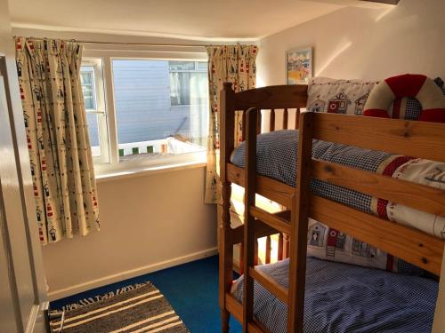 ein Schlafzimmer mit Etagenbett und Fenster in der Unterkunft Seabirds - 3 bed chalet, dog friendly, Bridlington in Bridlington