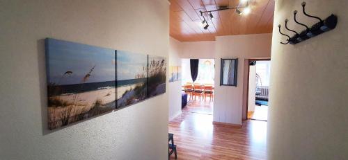 einen Flur mit zwei Gemälden an den Wänden eines Hauses in der Unterkunft Annemaries Nordseehaus in Butjadingen
