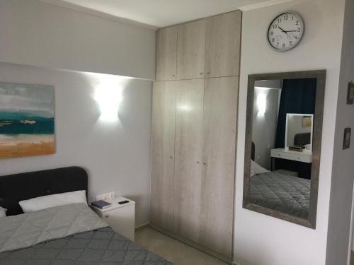 a bedroom with a bed and a clock on the wall at Sea view apartment in Loutraki