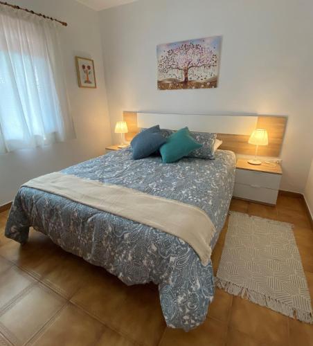 a bedroom with a large bed with blue pillows at Casa Zawadi in Mijas