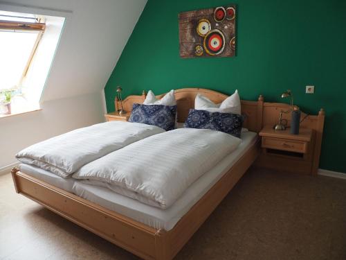 a bed in a room with a green wall at Landblick in Nahrendorf