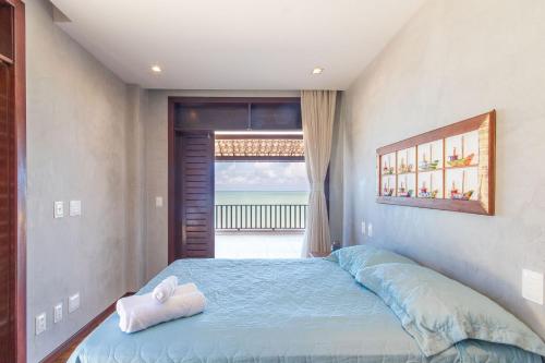 Un dormitorio con una cama con una toalla. en Casa de Luxo na Beira Mar de Porto Mirim/RN en Jacumã