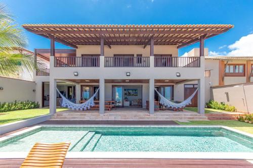 uma villa com uma piscina e uma casa em Casa de Luxo na Beira Mar de Porto Mirim/RN em Jacumã
