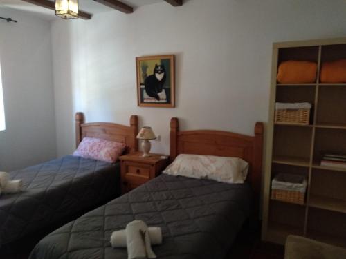 sypialnia z 2 łóżkami i zdjęciem kota na ścianie w obiekcie La Casa Del Venancio w mieście Caleruega