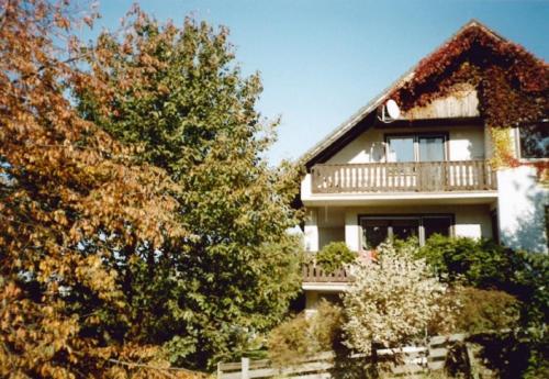 ein großes Haus mit einem Balkon und einem Baum in der Unterkunft Ferienwohnung Troglauer in Letzau