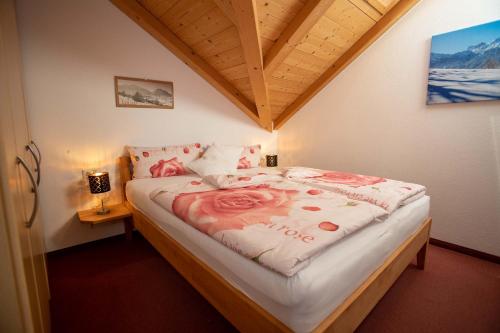 a bedroom with a bed with a rose blanket on it at Landhaus Wanger in Pfronten