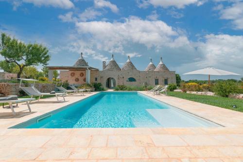 einen externen Blick auf eine Villa mit einem Pool in der Unterkunft Trulli Gianpaolo - Luxury Villa in Ostuni