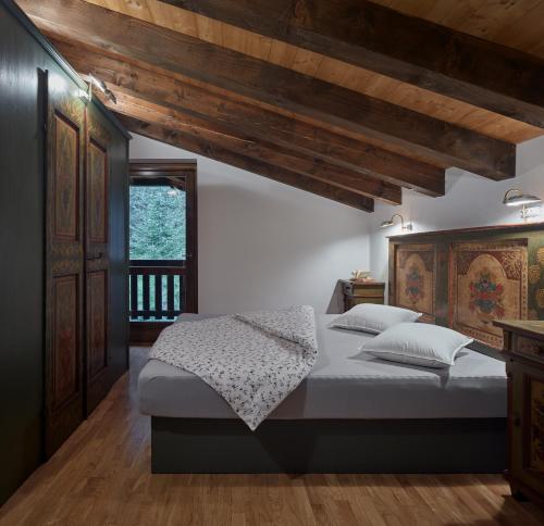 a bedroom with a bed and a wooden ceiling at Casa Sauris in Sauris