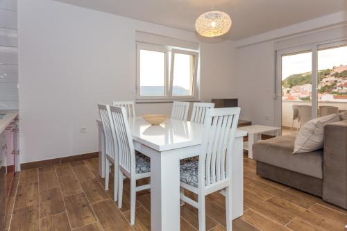 a white dining room table with chairs and a couch at Holiday Home in Komarna