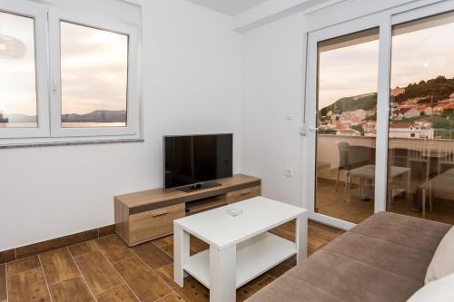 a living room with a couch and a tv and a table at Holiday Home in Komarna