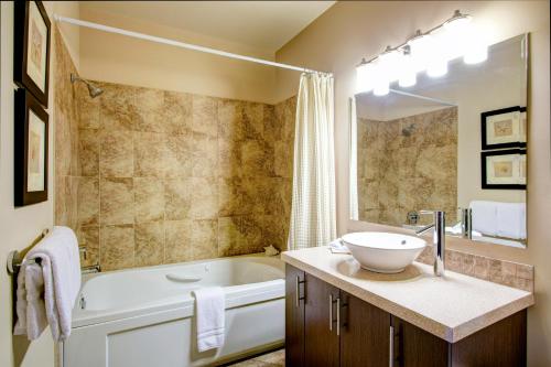 a bathroom with a tub and a sink and a bath tub at Sunrise Ridge Waterfront Resort in Parksville