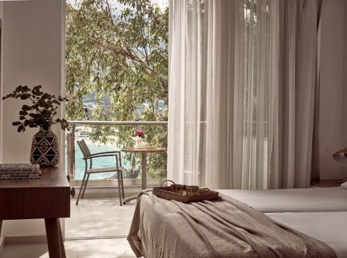 a bedroom with a bed and a large window at Troulis Apart-Hotel in Bali
