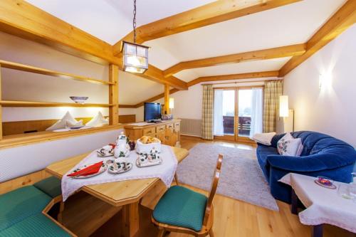 ein Wohnzimmer mit einem Tisch und einem blauen Sofa in der Unterkunft Alpenglühn in Reit im Winkl