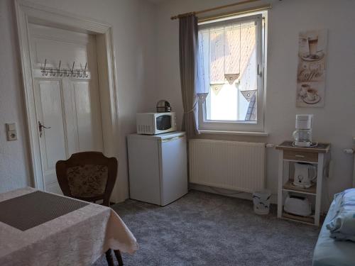 a small room with a refrigerator and a microwave at Ferienwohnung in der Altstadt von Coswig Anhalt Gästezimmer in Coswig