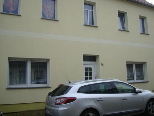a silver car parked in front of a building at Ferienwohnung in der Altstadt von Coswig Anhalt Gästezimmer in Coswig