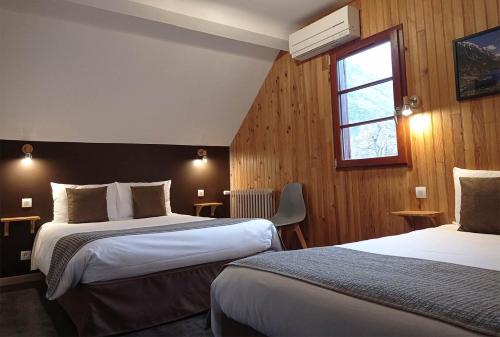 um quarto de hotel com duas camas e uma janela em Hôtel de la Gare em Pierrefitte-Nestalas