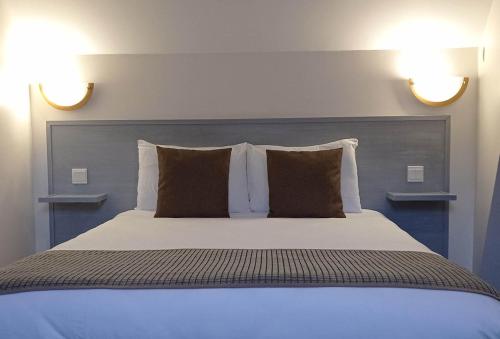 a bedroom with a large bed with two pillows at Hôtel de la Gare in Pierrefitte-Nestalas
